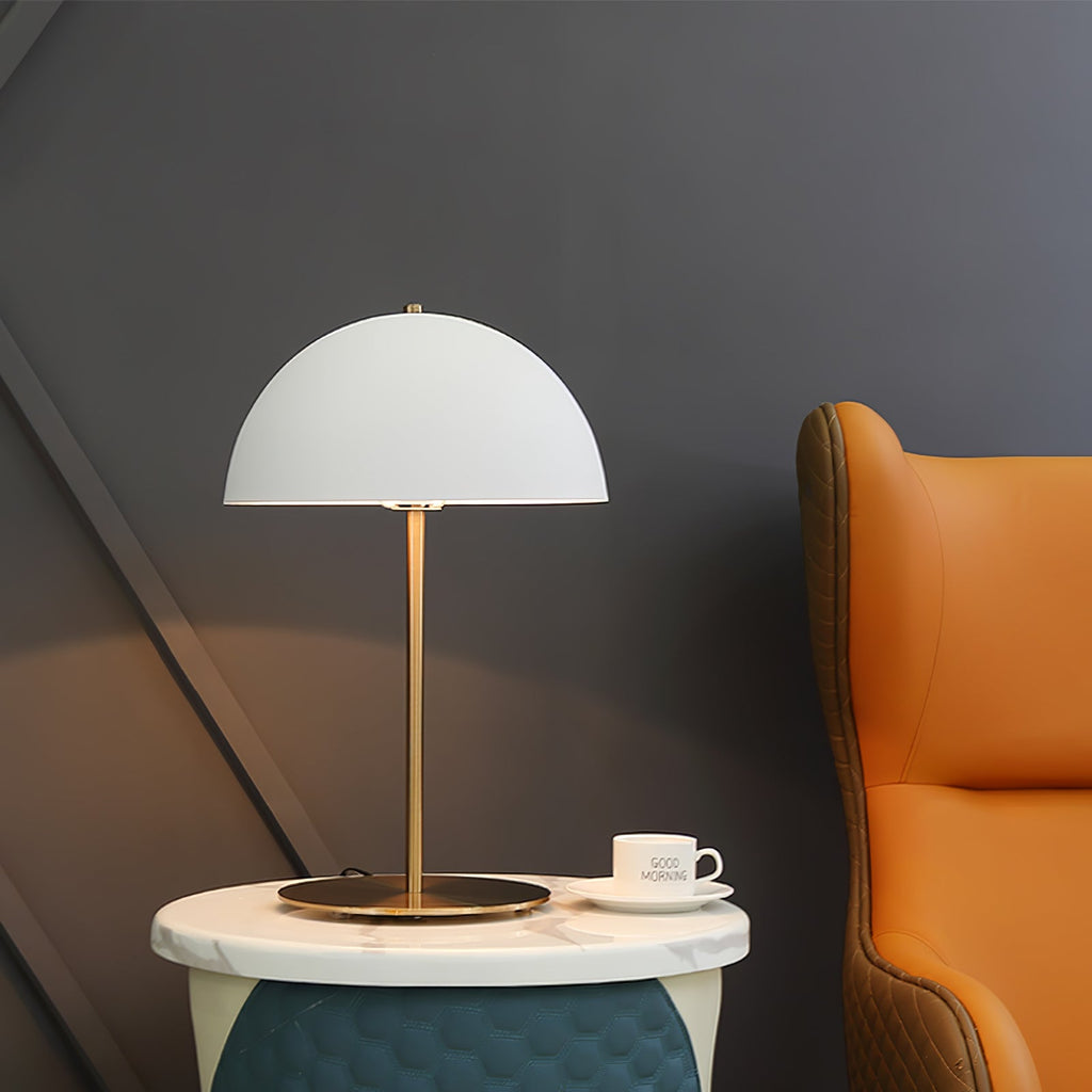 This Clérachic table lamp with a white dome shade stands on a marble-topped bedside table beside a cup and saucer.