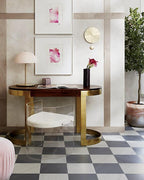 Small pink dome lamp from Clérachic on a dark wood console with a red flower in a vase, above a chequered floor.