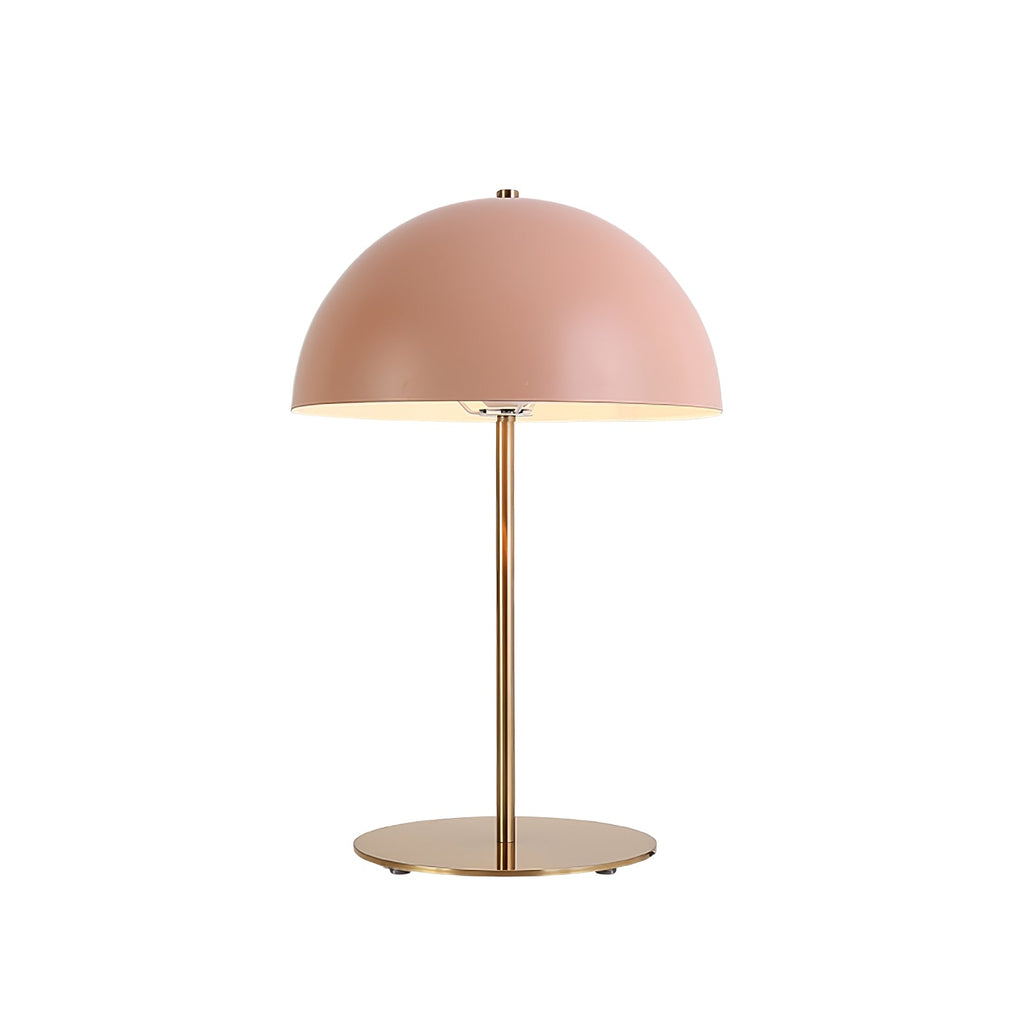 Pink dome table lamp from Clérachic on a white backdrop, its brass stem rising from a round base with tiny rubber pads.