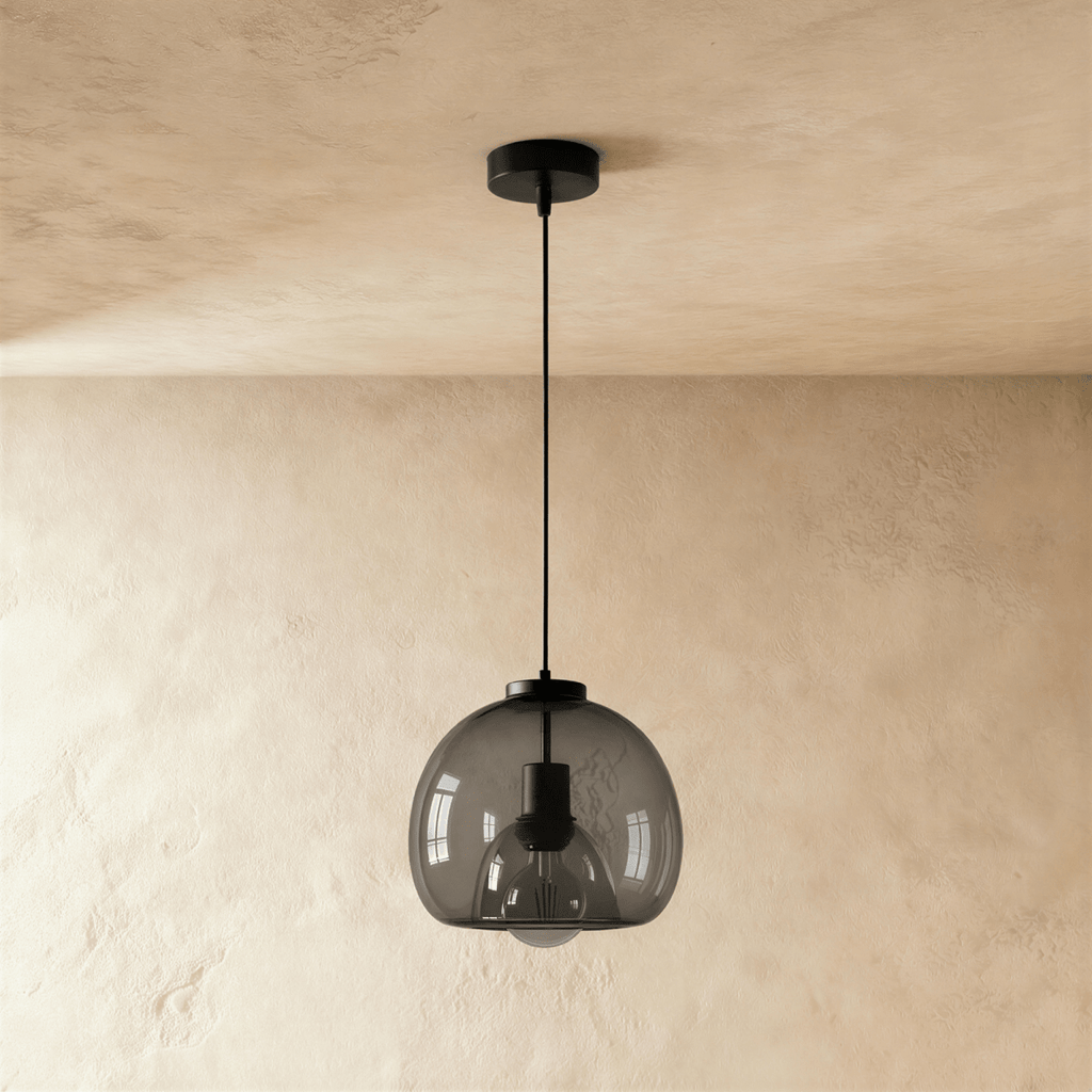 Clérachic single smoked glass pendant with matte black cord and canopy, shown unlit against a limewashed wall.