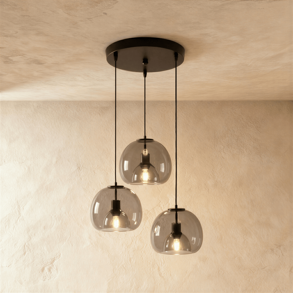 Clérachic three-light pendant cluster with smoked glass shades hanging at three heights from a round matte black canopy.