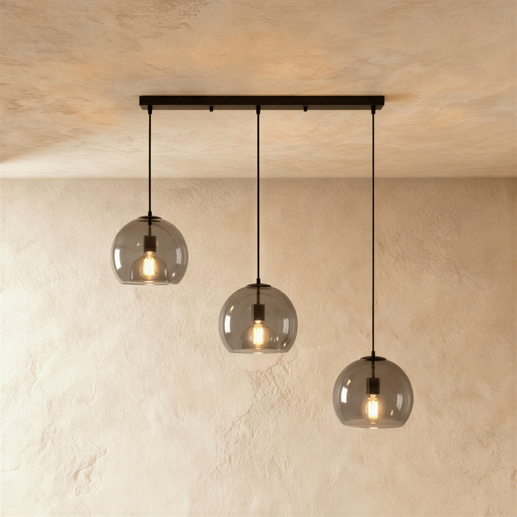 Clérachic three-light pendant with smoked glass shades at stepped heights from a slim linear matte black bar canopy.