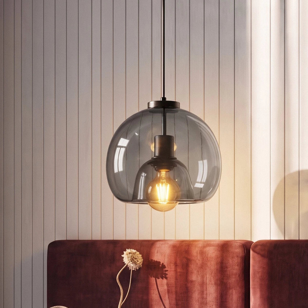 Clérachic smoked glass pendant lit above a burgundy velvet sofa against vertical timber panelling.