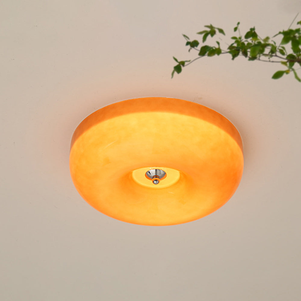 The Clérachic Domed Glass Ceiling Light in orange glass, lit to a deep amber that fills the dome evenly from edge to edge.