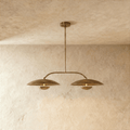 Clérachic chandelier in vintage brass, two dome shades hung from an angled bar with a central rod.
