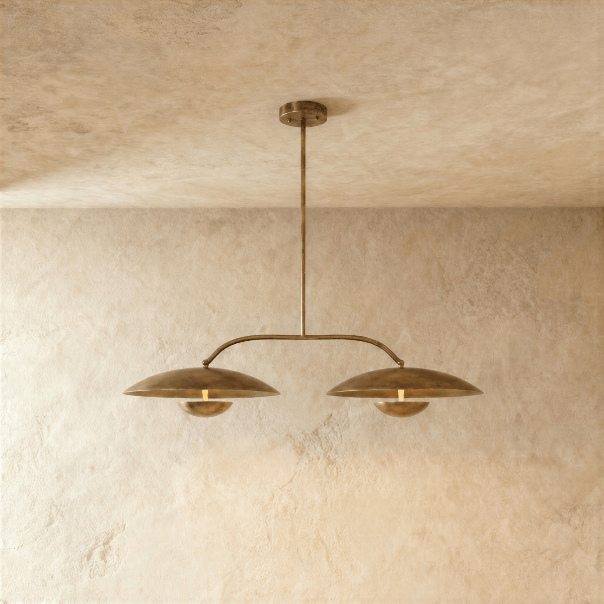 Clérachic chandelier in vintage brass, two dome shades hung from an angled bar with a central rod.