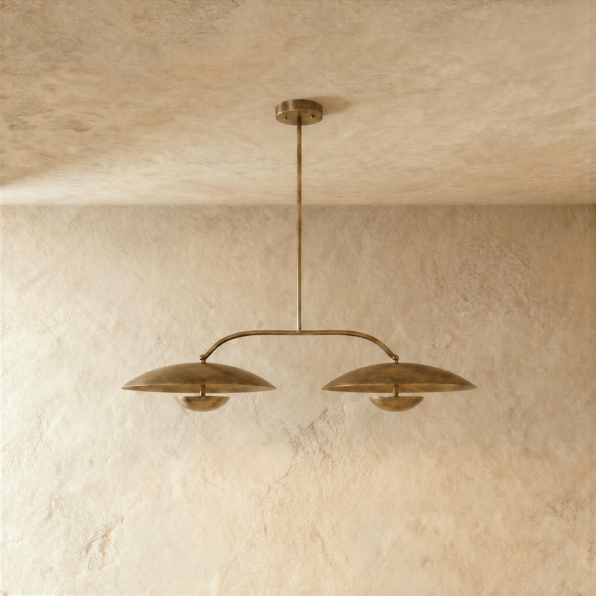 Clérachic chandelier in vintage brass, close view of the paired dome shades and slender crossbar.