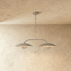 Clérachic chandelier in chrome, twin dome shades suspended from an angled bar against plaster.