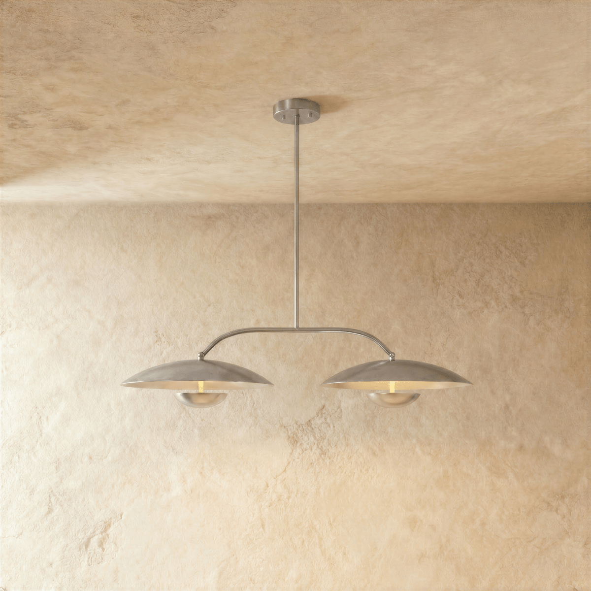 Clérachic chandelier in chrome, twin dome shades suspended from an angled bar against plaster.