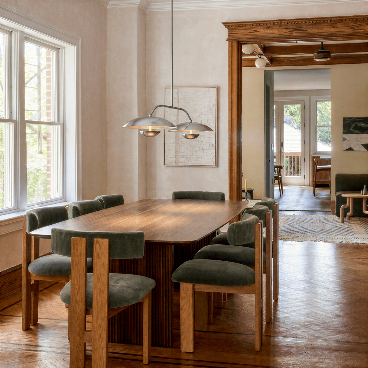 Clérachic chandelier in chrome over a dining table framed by a ribbed wood accent wall and mirror.