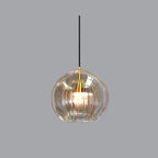 Studio view of the Clérachic double-wall globe pendant on a grey ground, clear outer sphere over a brass-lit fluted inner shade.