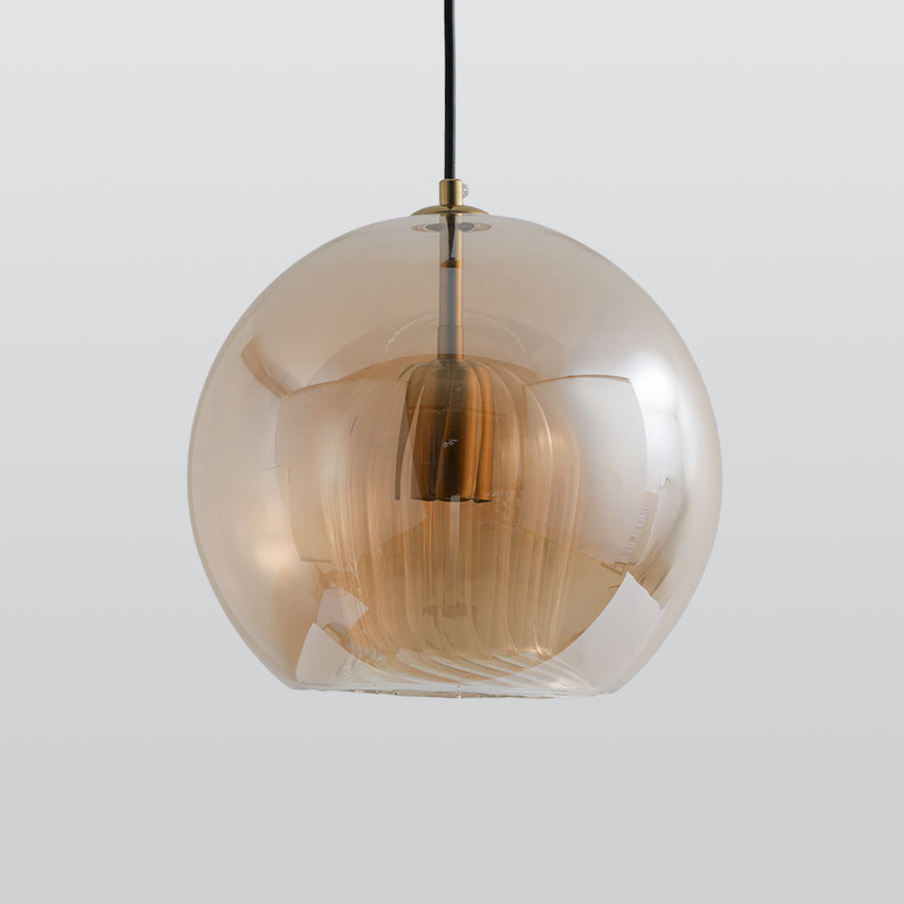 The Clérachic double-wall globe pendant in amber glass, flat-cut base and fluted inner shade shown against a grey studio ground.