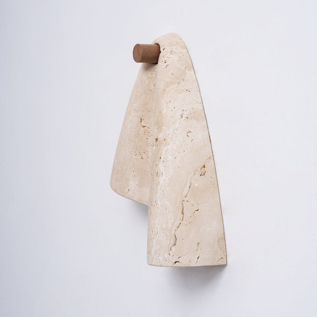 Profile of the Clérachic sconce showing the cylindrical wood knob that holds the folded travertine away from the wall.