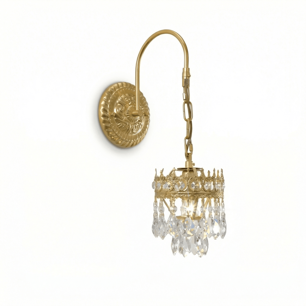 Angled view of this Clérachic wall light, its curved arm, chain and crown of clear crystal drops hanging below an embossed round backplate.