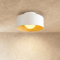 Clérachic white metal drum ceiling light with a wood-grain interior and an opal ball glowing warm, on a limewashed ceiling.