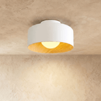 Clérachic white metal drum ceiling light with a wood-grain interior and an opal ball glowing warm, on a limewashed ceiling.