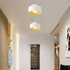 Clérachic two white drum ceiling lights glowing warm in a hallway with slatted wood panelling, a shoe cupboard and stairs.