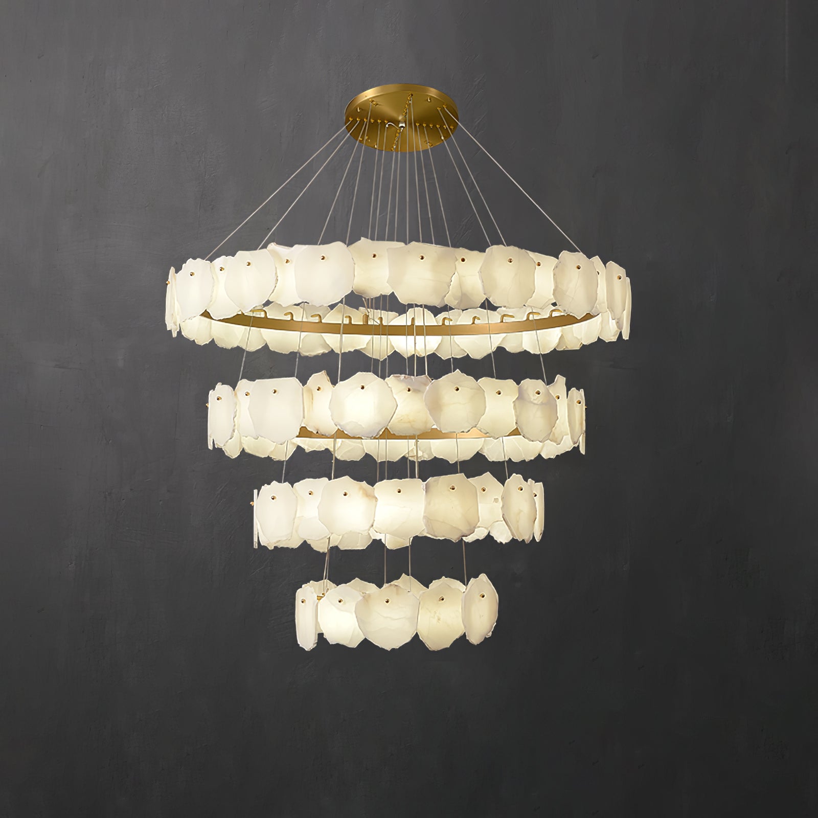 Clérachic Ecliptica chandelier on charcoal, four brass rings hung with overlapping alabaster petals.