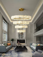 Clérachic Ecliptica chandelier hung in a double-height living room above a marble fireplace.