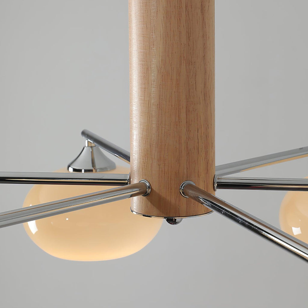 Close view of the wooden centre column on this Clérachic chandelier, with chrome arms leaving it and a glass shade beneath.