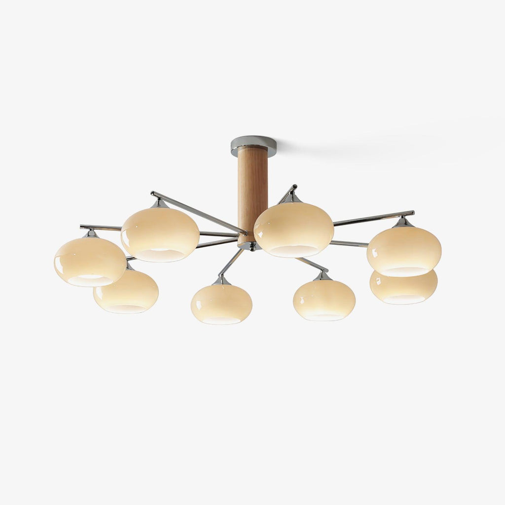 Lit chandelier from Clérachic with eight creamy yellow glass shades and chrome arms, shown on a clean pale background.