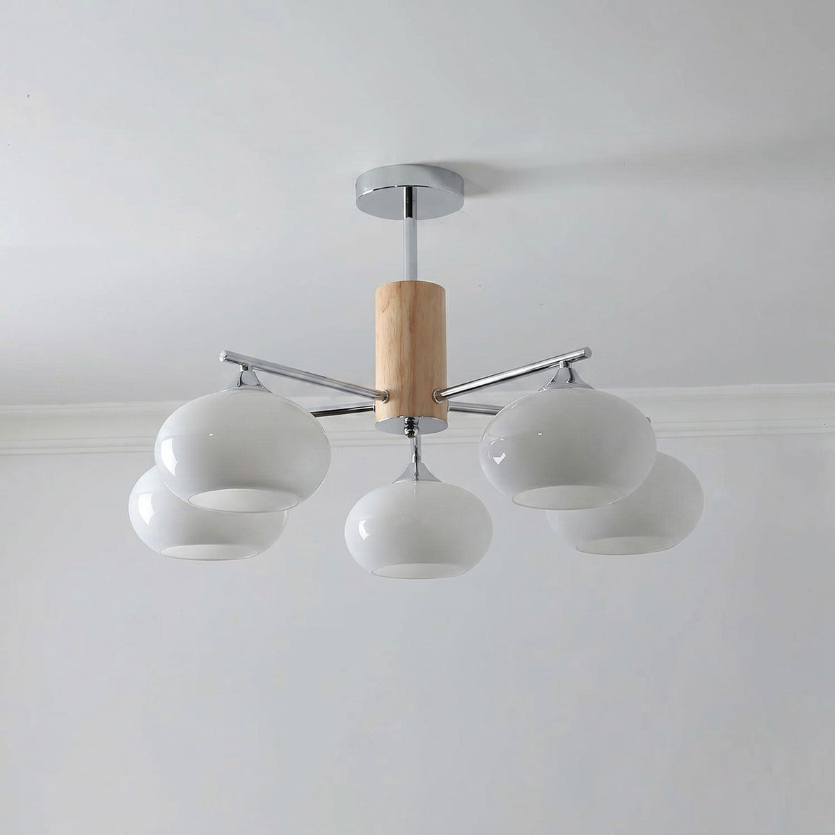 Five-light chandelier from Clérachic with milk white glass shades clustered around a wooden column and a chrome rod.