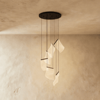 Clérachic brilliant black chandelier with a round ceiling plate, its wavy acrylic sheets glowing warm below.