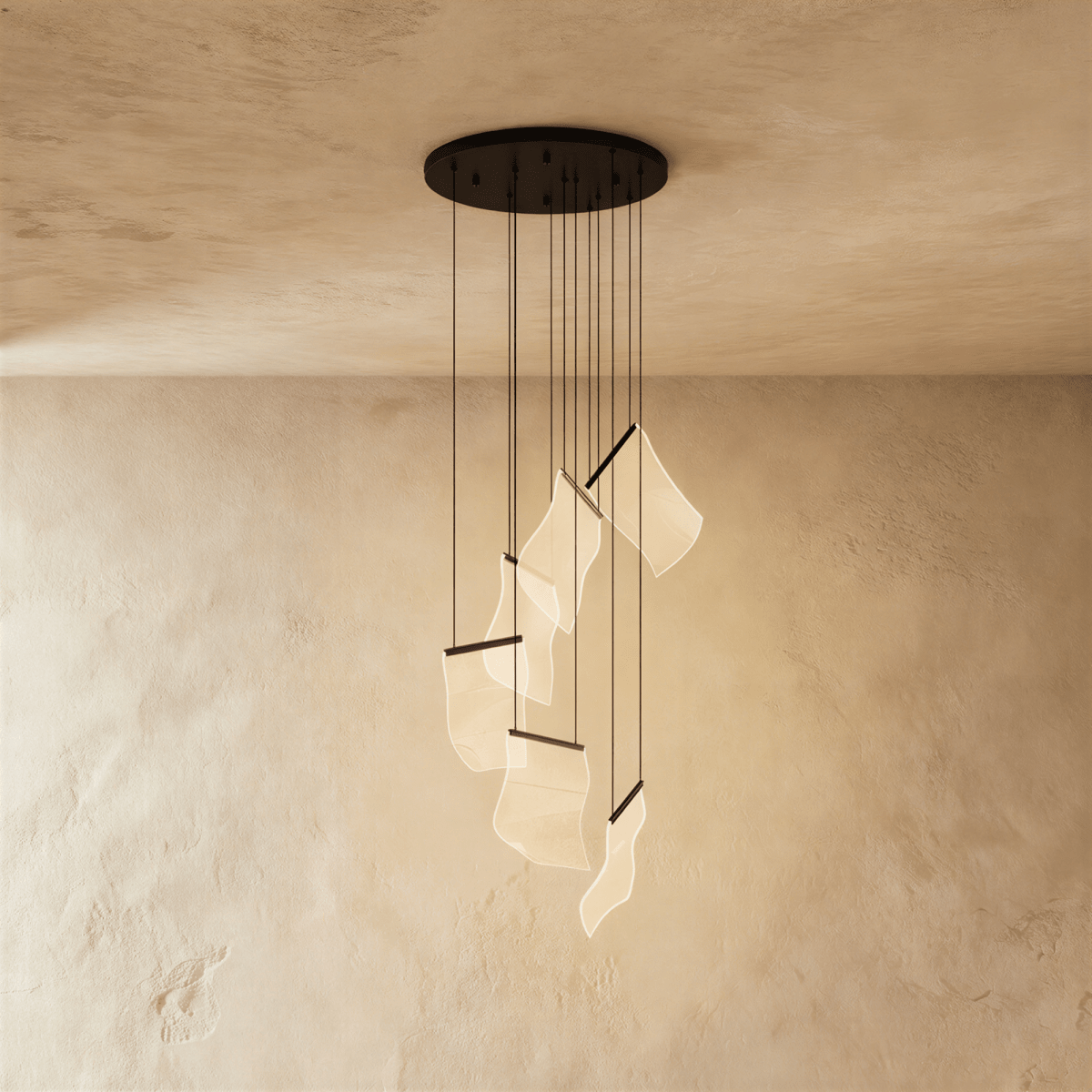 Clérachic brilliant black chandelier with a round ceiling plate, its wavy acrylic sheets glowing warm below.