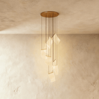 Clérachic gold chandelier with a spiral of glowing acrylic sheet pendants hanging from a brass ceiling disc.