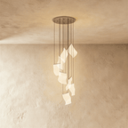 Clérachic empress gold chandelier, its cluster of sculpted acrylic panes catching warm light near the wall.