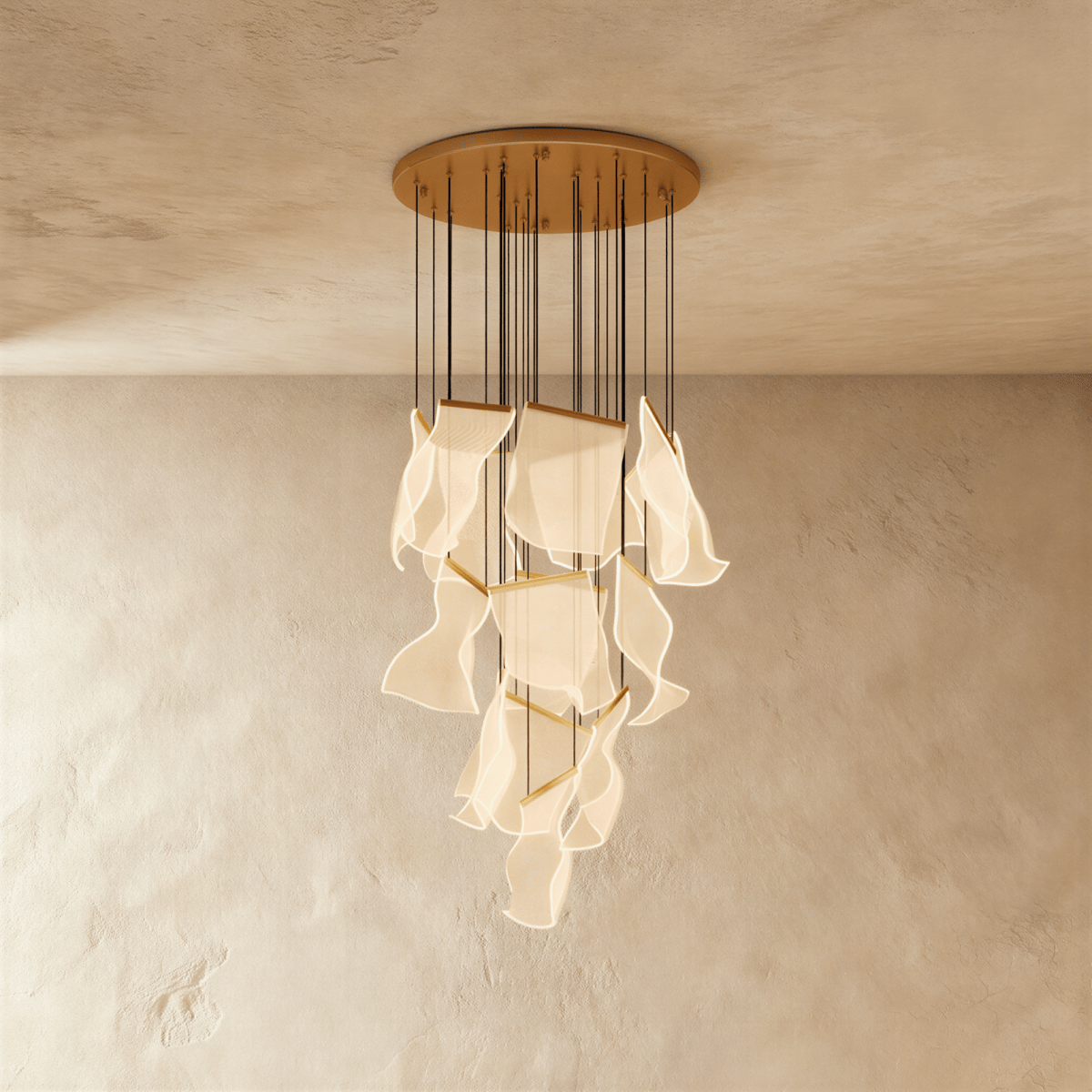 Clérachic gold chandelier showing its tiered brass bars and glowing acrylic sheets against a warm plaster wall.