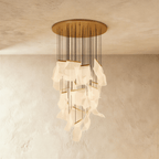 Clérachic gold chandelier, a tall column of warm acrylic sheet pendants catching light near the ceiling plate.