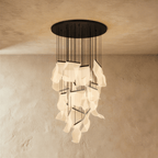 Clérachic brilliant black chandelier shown with its full cascade of glowing acrylic sheets against a plaster wall.