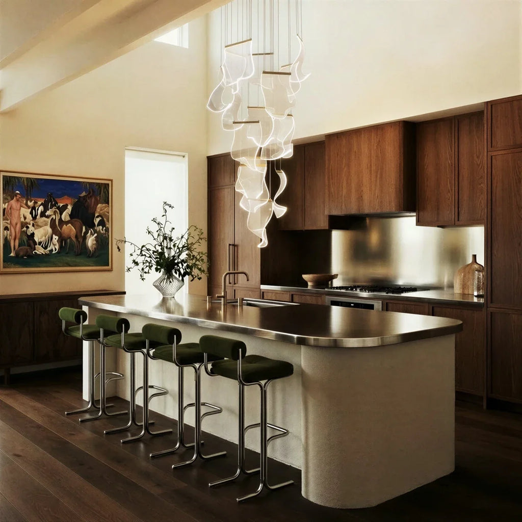 Clérachic sheet-pane chandelier hung above a kitchen island, its tall acrylic cascade lighting the dark wood cabinetry.