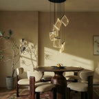 Clérachic chandelier hanging above a round dining table, its acrylic sheets glowing warm in late afternoon light.