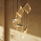 Clérachic chandelier's acrylic sheet panes glowing warm against a sunlit plaster wall, cords catching the light.