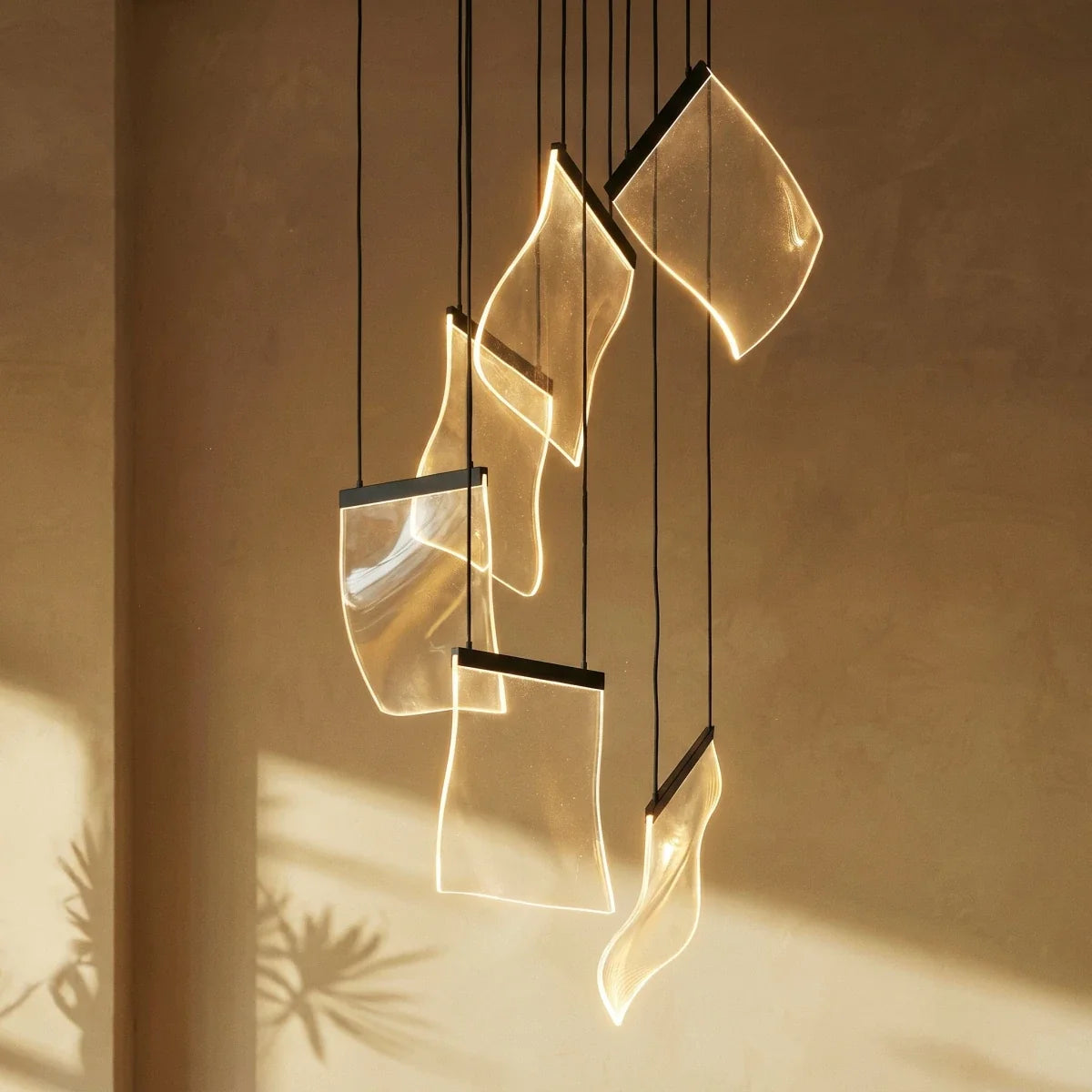 Clérachic chandelier's acrylic sheet panes glowing warm against a sunlit plaster wall, cords catching the light.