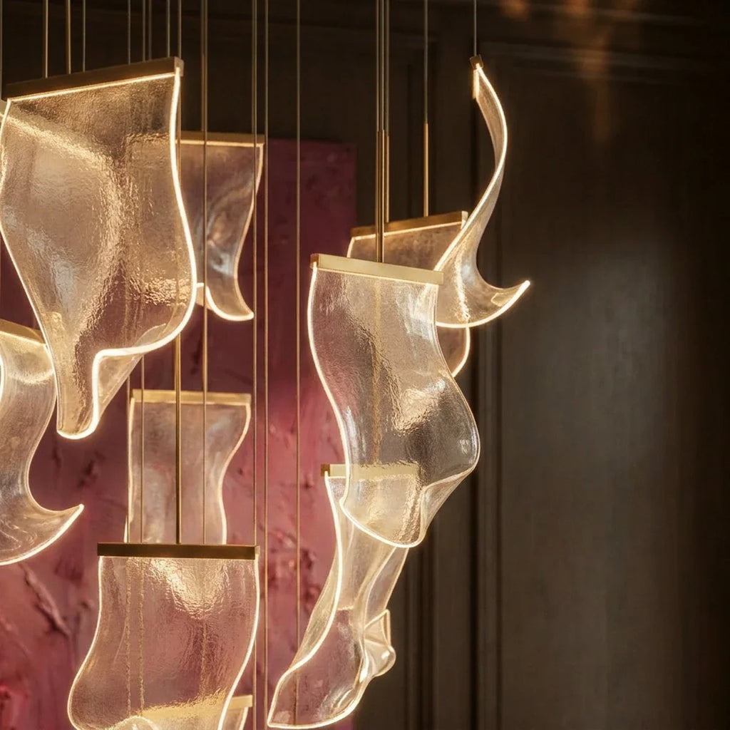 Clérachic chandelier detail, several glowing acrylic sheet panes shown close against a dim burgundy-toned room.