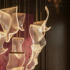 Clérachic chandelier detail, several glowing acrylic sheet panes shown close against a dim burgundy-toned room.
