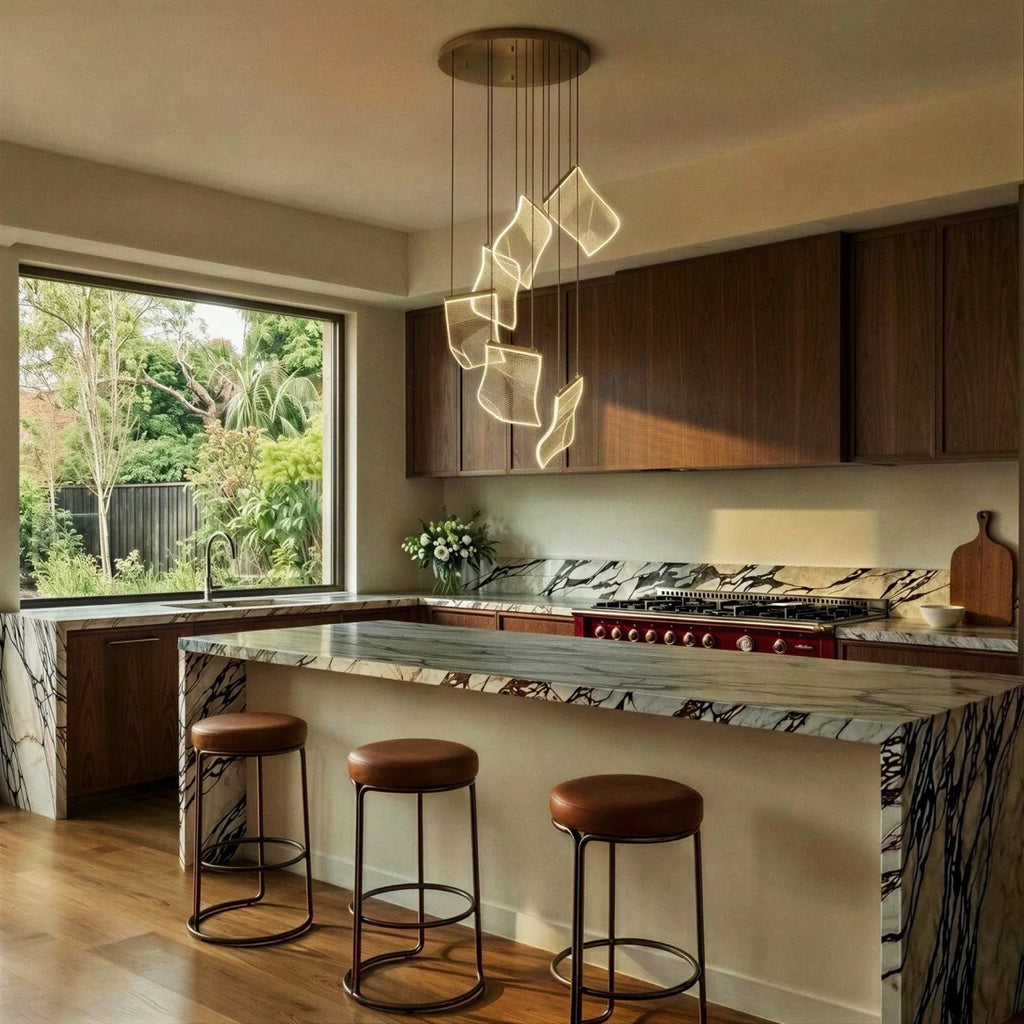 Clérachic chandelier suspended above a marble kitchen island, its acrylic sheets glowing beside a garden window.