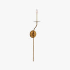 Clérachic's Eris wall lamp in brass, unlit, its slender arm standing straight against white.