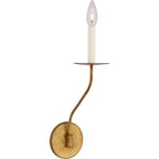 Clérachic's Eris wall lamp lit in brass on white, the cream candle cover glowing at its tip.