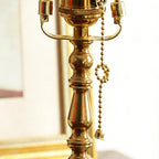 Close view of the turned brass stem, bulb holders and beaded pull chain on this Clérachic table lamp.