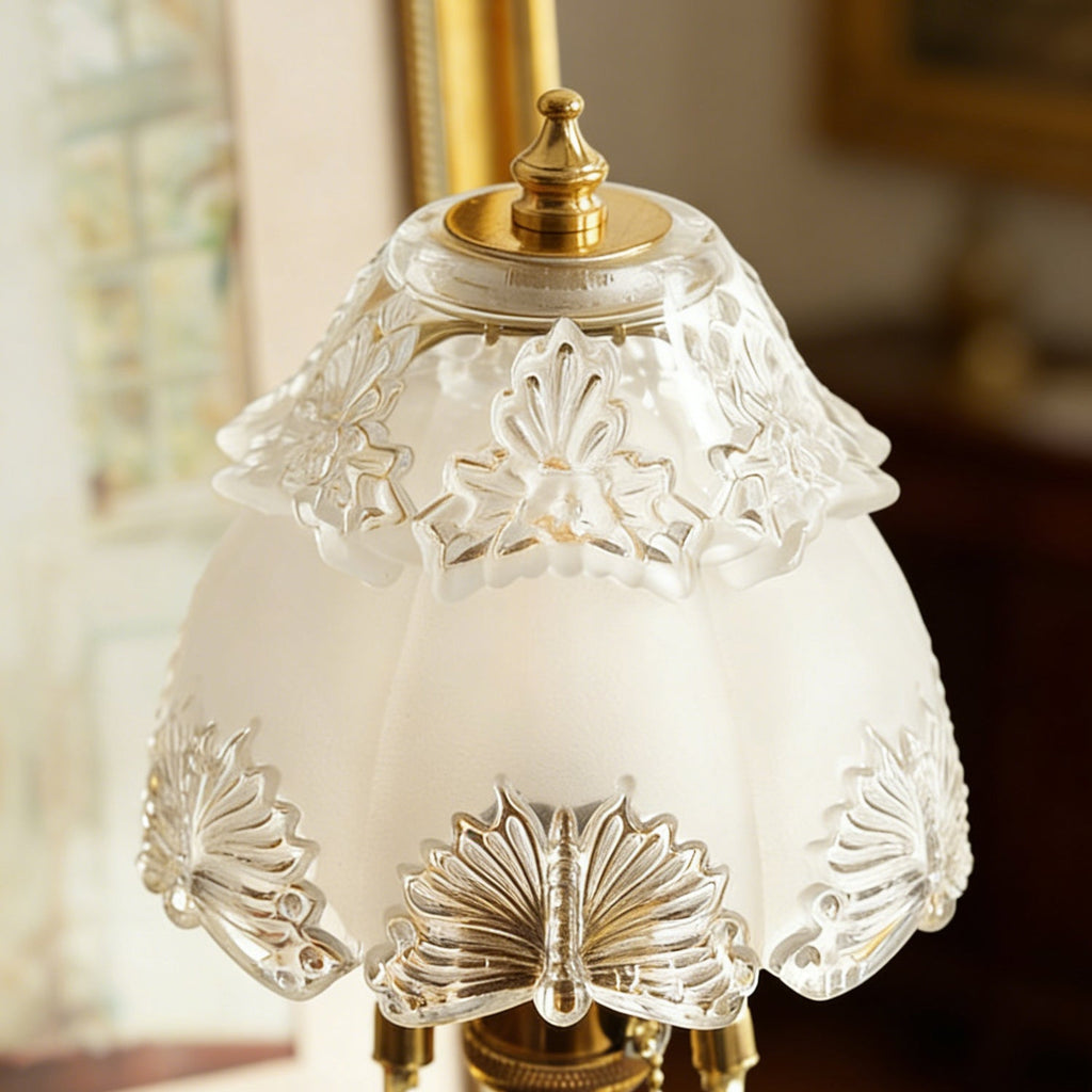 Close view of the etched floral pattern on the frosted glass shade and the brass finial on top of this Clérachic table lamp.