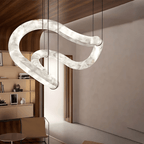 Clérachic Ethereal chandelier seen from the side, alabaster loop against pale plaster walls.
