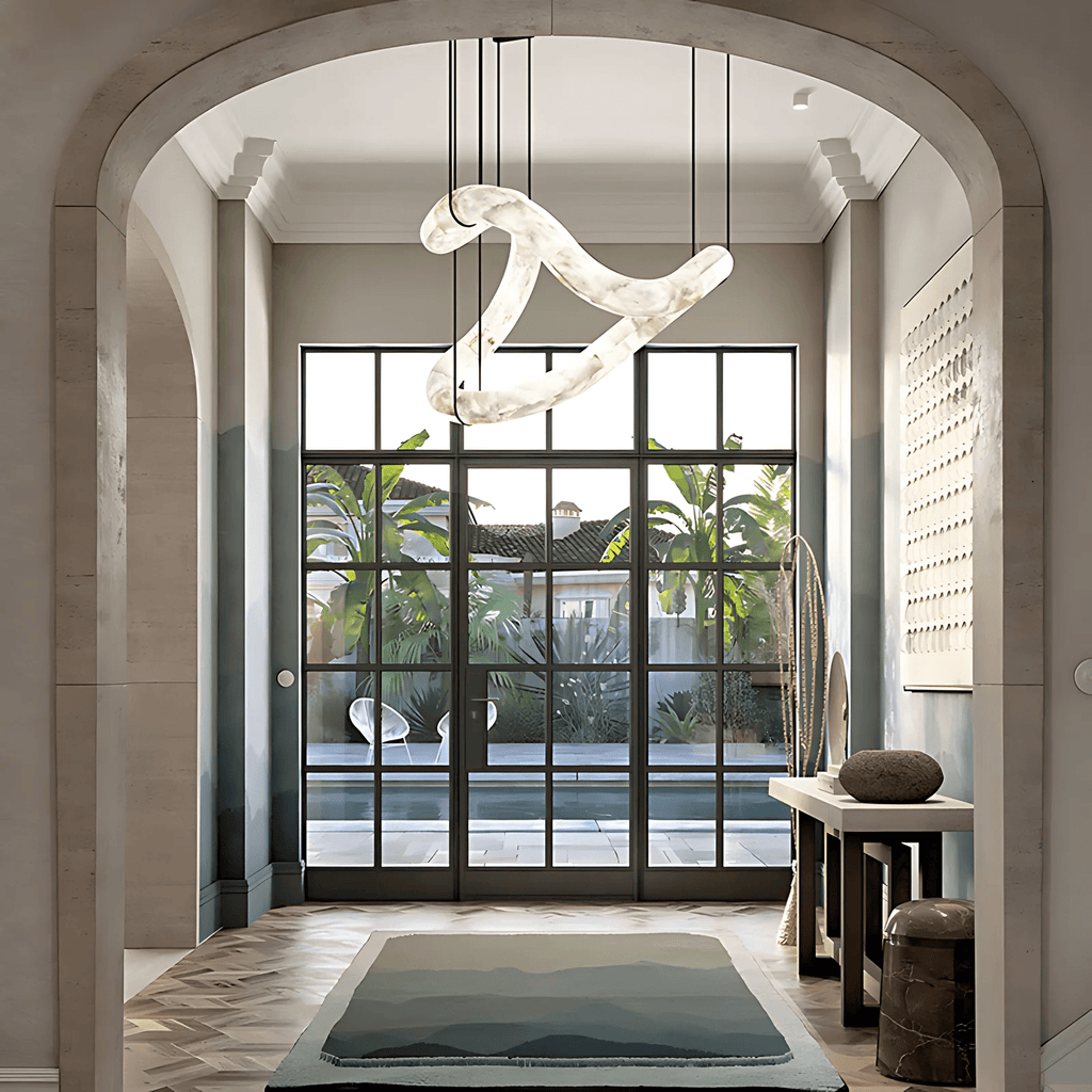The Clérachic Ethereal chandelier in a tall arched hall, palms visible through steel windows.