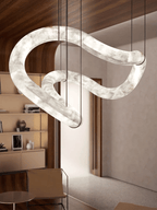 Clérachic Ethereal chandelier at an angle beneath wood panelling, its curve catching the light.