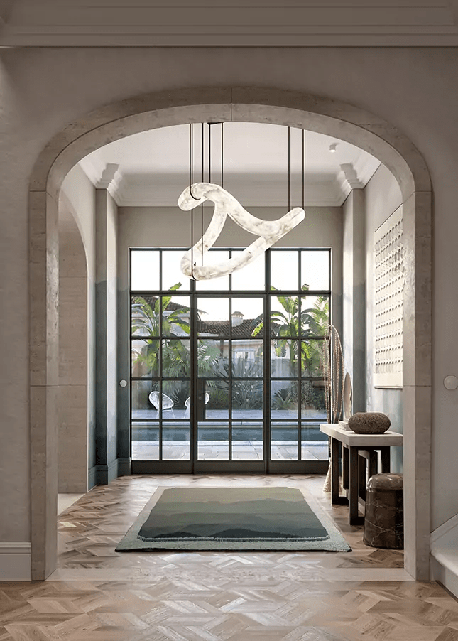 The Clérachic Ethereal chandelier framed by a stone archway, herringbone floor beyond.