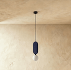 Clérachic single pendant with a navy fabric pill panel and a matte milk white glass globe on a black cord and canopy.