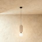 Clérachic single pendant with a sand beige fabric pill panel over a milk white glass globe, on a warm plaster wall.